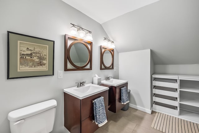 bathroom with lofted ceiling, vanity, tile patterned floors, and toilet