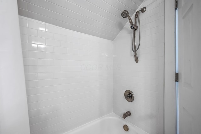 bathroom with tiled shower / bath and vaulted ceiling