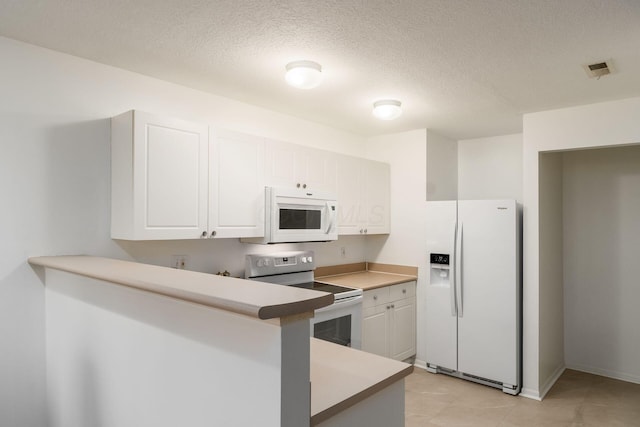 kitchen featuring white appliances, kitchen peninsula, a textured ceiling, and white cabinets