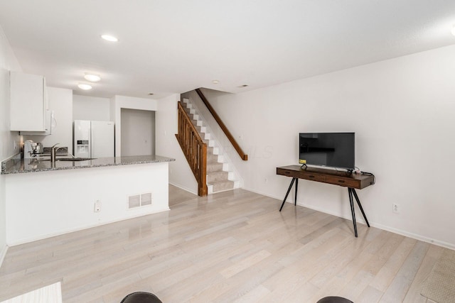 7083 Gallant Fox Dr Unit 4, New Albany, OH 43054 - kitchen with white refrigerator with ice dispenser, stone countertops, white cabinetry, light wood finished floors, and a peninsula