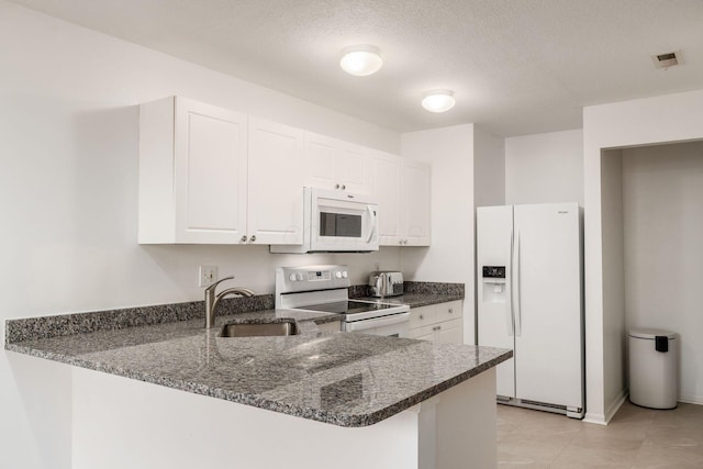 7083 Gallant Fox Dr Unit 4, New Albany, OH 43054 - kitchen with white appliances, a sink, a peninsula, white cabinetry, and dark stone countertops