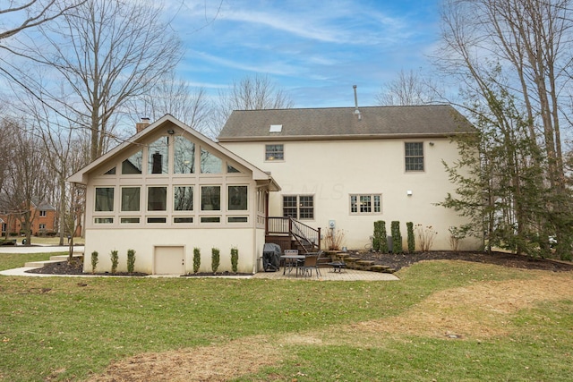 back of house with a yard, a patio, a chimney, and stucco siding