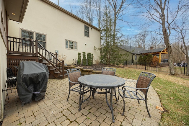 view of patio / terrace with a grill, outdoor dining space, and fence