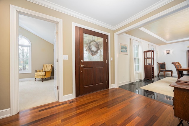 entrance foyer with visible vents, crown molding, baseboards, and wood finished floors