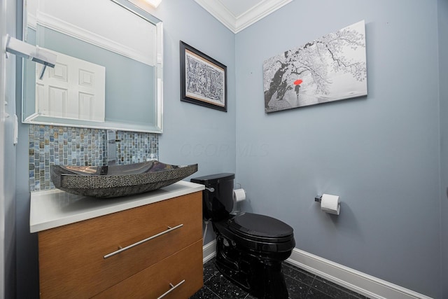 half bath featuring vanity, baseboards, crown molding, toilet, and backsplash