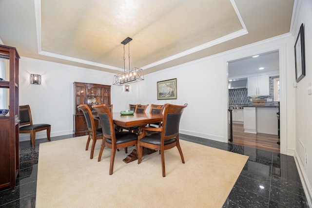 dining space featuring a tray ceiling, baseboards, crown molding, and granite finish floor