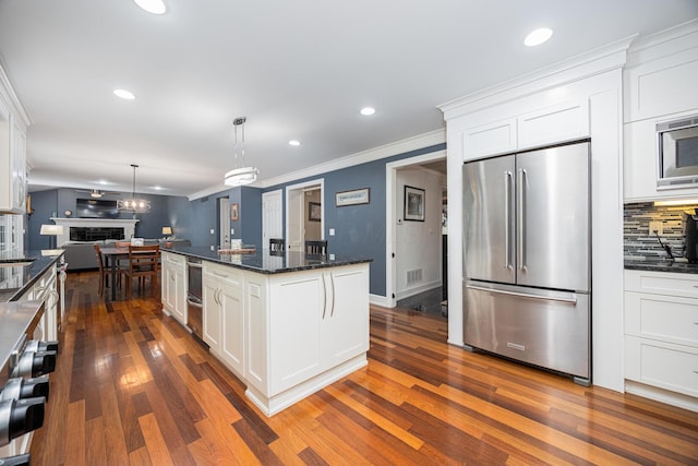 kitchen featuring visible vents, dark wood-type flooring, white cabinets, appliances with stainless steel finishes, and open floor plan