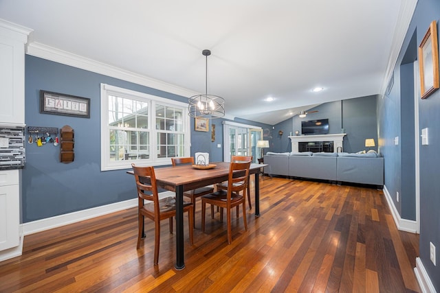 dining area featuring dark wood-type flooring, a fireplace, and baseboards