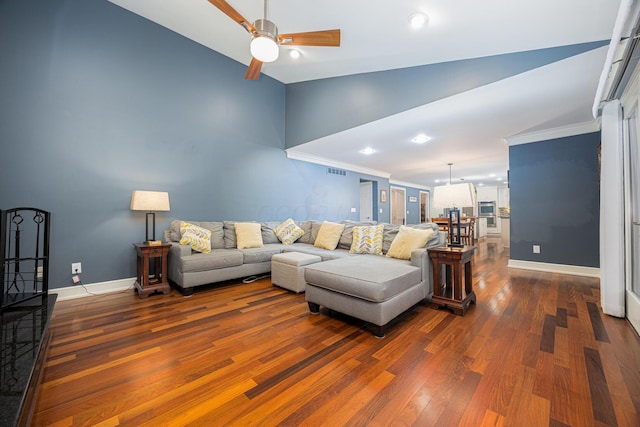 living room featuring baseboards, lofted ceiling, dark wood-type flooring, and ornamental molding