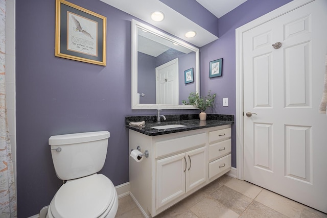 full bathroom with toilet, vanity, and baseboards