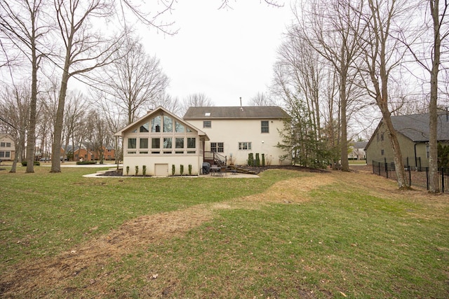 rear view of house with a patio, a lawn, fence, and a sunroom