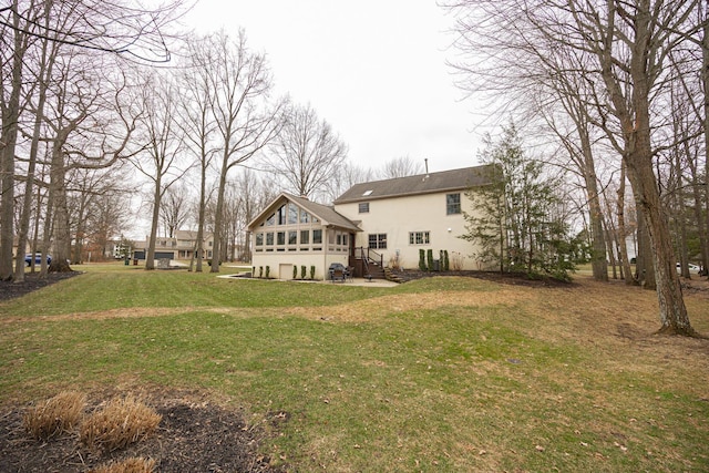 rear view of property featuring a yard and stucco siding