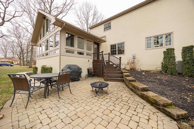 back of house with outdoor dining space, an outdoor fire pit, central AC, stucco siding, and a patio area