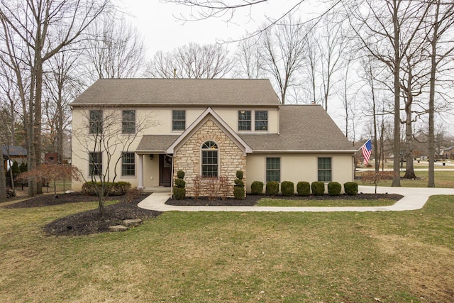 traditional-style house with stone siding, stucco siding, a shingled roof, and a front yard