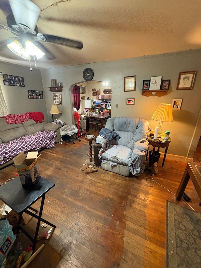 living room with hardwood / wood-style flooring, a textured ceiling, and ceiling fan