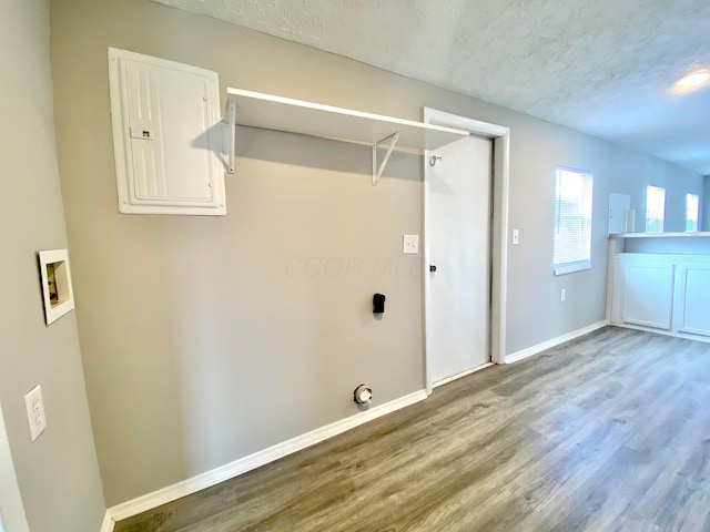 laundry area with hardwood / wood-style flooring, washer hookup, electric panel, and a textured ceiling