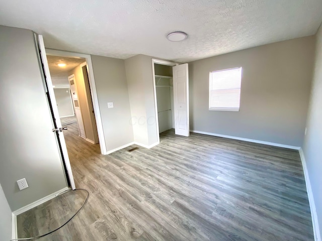 unfurnished bedroom featuring light hardwood / wood-style flooring, a closet, and a textured ceiling