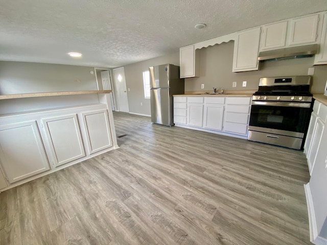 kitchen featuring a textured ceiling, light wood-type flooring, white cabinets, and appliances with stainless steel finishes