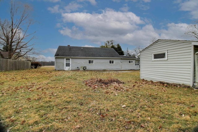 back of house with a storage unit, fence, an outdoor structure, and a yard