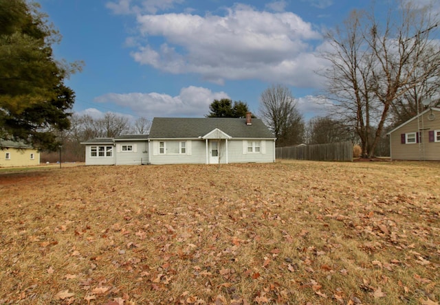 view of front of property featuring a front yard, fence, and a chimney