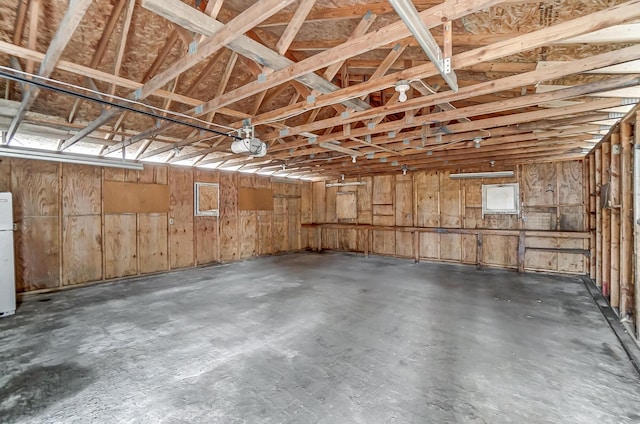 garage with a garage door opener and white fridge