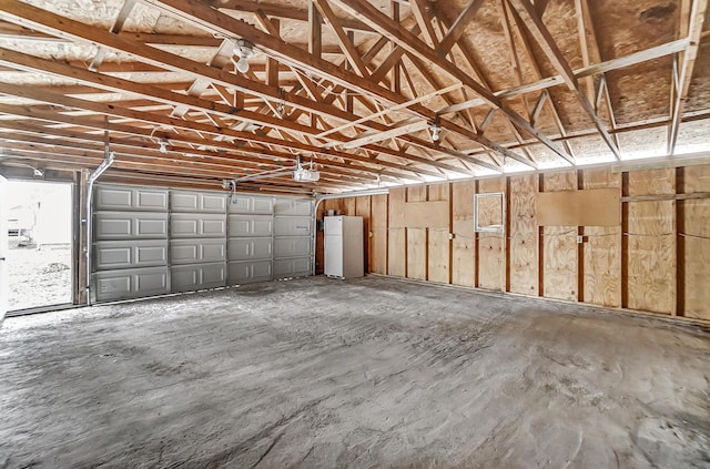 garage featuring white refrigerator and a garage door opener