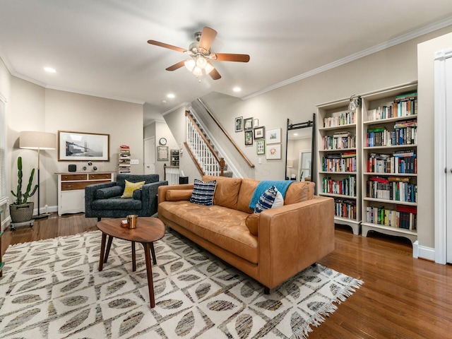 living room with hardwood / wood-style flooring, ceiling fan, and ornamental molding