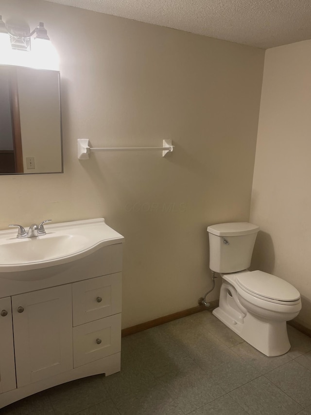 bathroom featuring vanity, a textured ceiling, and toilet