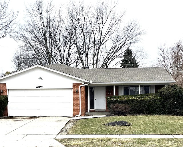 ranch-style house featuring a garage and a front yard