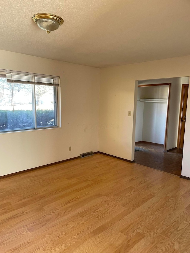 unfurnished bedroom featuring a textured ceiling and light wood-type flooring