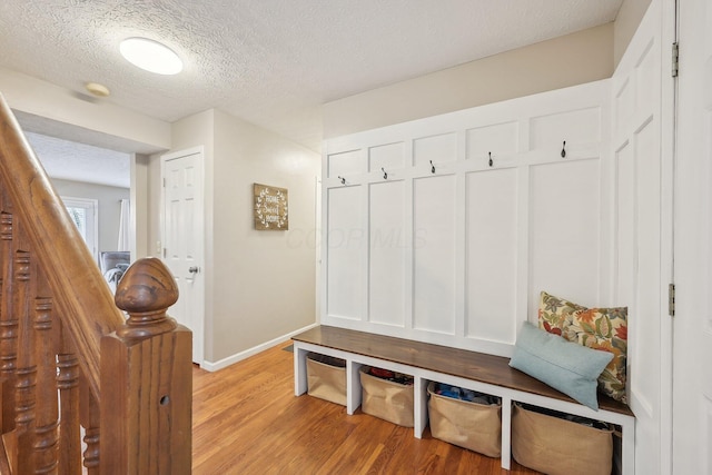 mudroom featuring a textured ceiling and light wood-type flooring