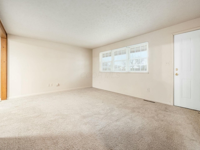 spare room with carpet flooring and a textured ceiling