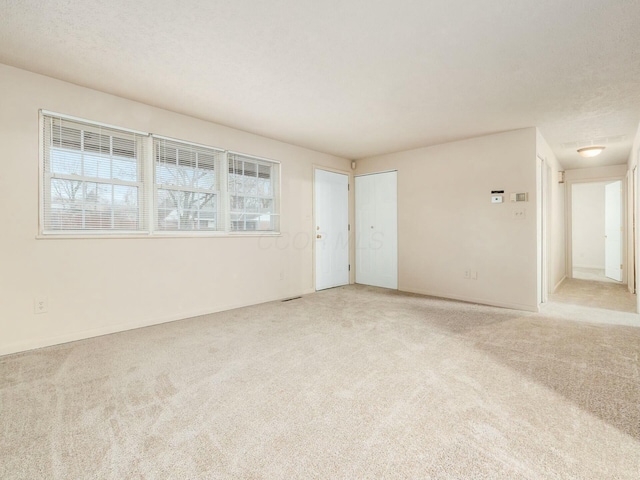 carpeted spare room featuring a textured ceiling