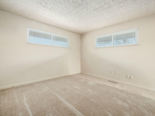 unfurnished room featuring carpet flooring and a textured ceiling