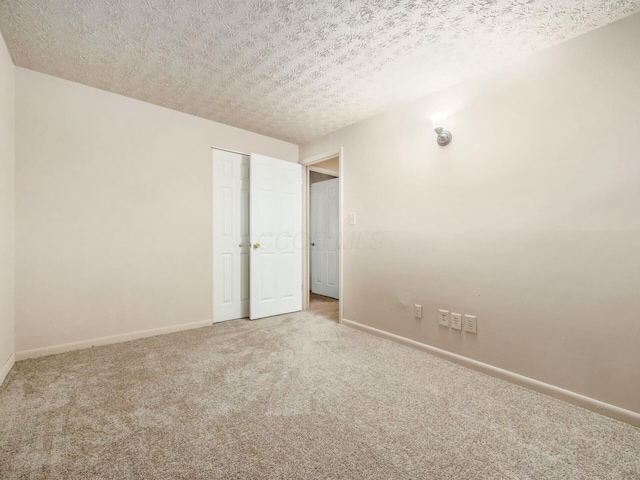 unfurnished bedroom with carpet floors, a closet, and a textured ceiling