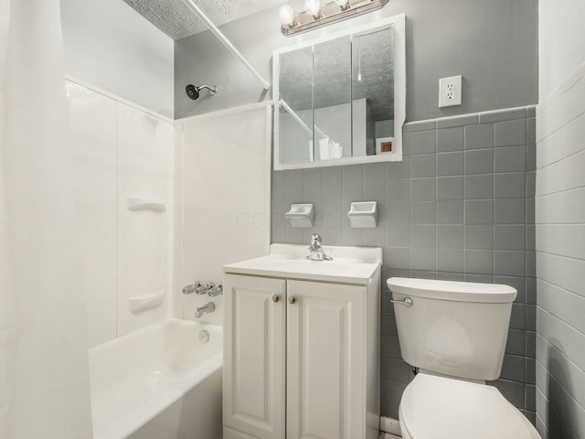 full bathroom featuring vanity, tile walls, toilet, and shower / bath combination