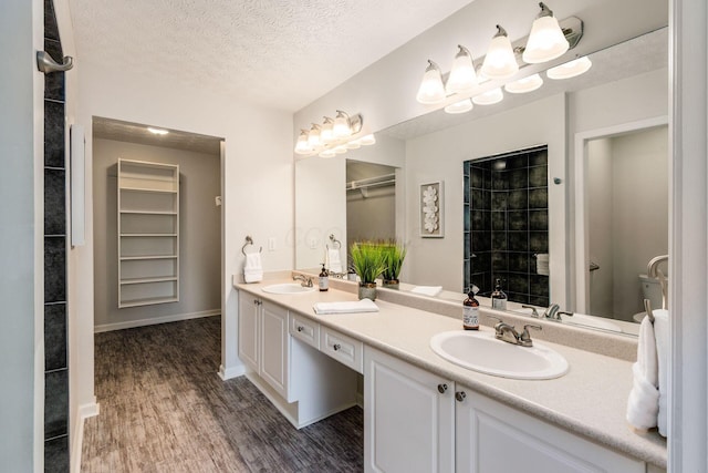4248 Bridgelane Pl Unit 8-4248, New Albany, OH 43054 - full bath with double vanity, wood finished floors, a textured ceiling, a walk in closet, and a tile shower
