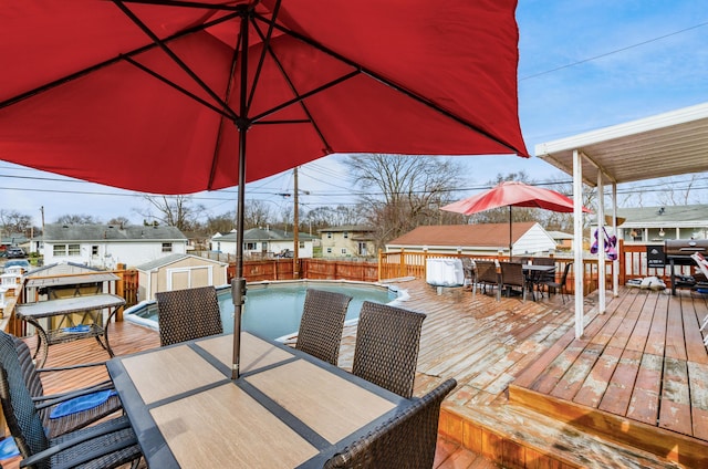 deck with a fenced in pool and a storage unit