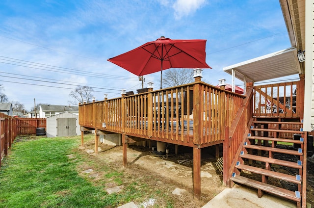 wooden terrace featuring a storage unit and a lawn