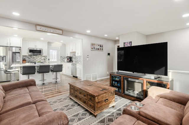 living room with sink and light hardwood / wood-style floors