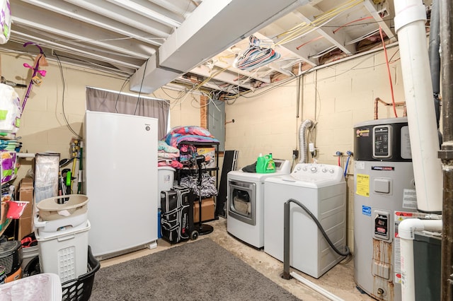 washroom featuring hybrid water heater and washing machine and dryer