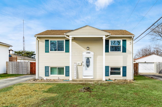 bi-level home with a garage, an outdoor structure, and a front lawn