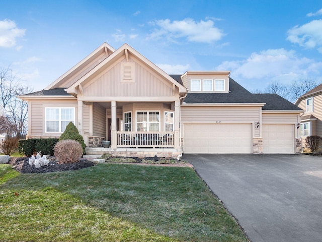 craftsman-style home featuring a garage, a front lawn, and covered porch