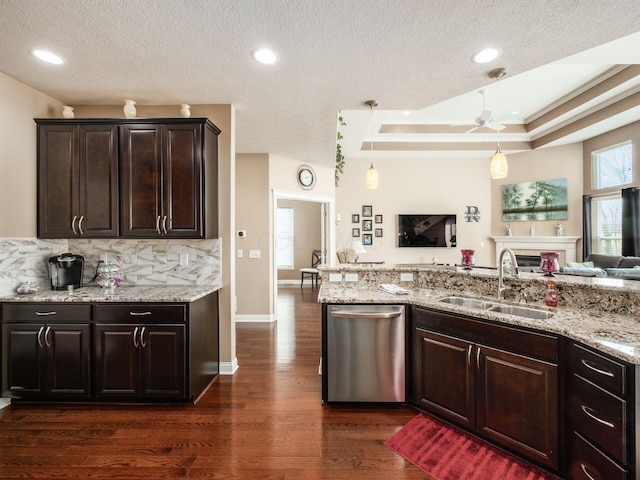 kitchen with sink, hanging light fixtures, stainless steel dishwasher, a tray ceiling, and dark brown cabinets