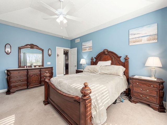 carpeted bedroom featuring lofted ceiling, ceiling fan, and a tray ceiling