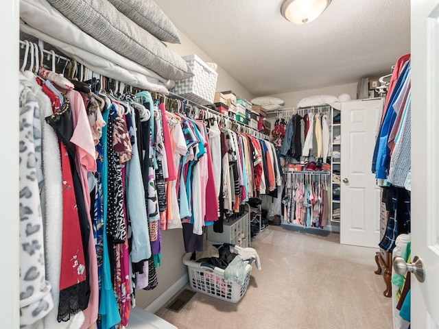 walk in closet featuring light carpet