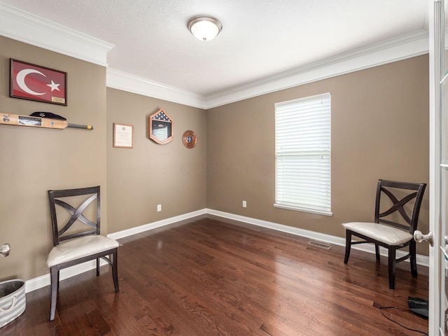 sitting room with crown molding and dark wood-type flooring