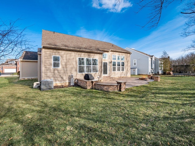 back of house featuring a lawn, central AC unit, and a patio area