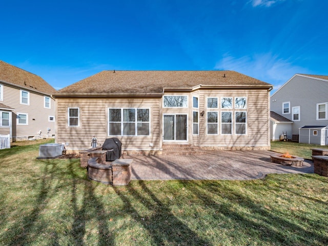 back of property with an outdoor fire pit, a yard, and a patio area