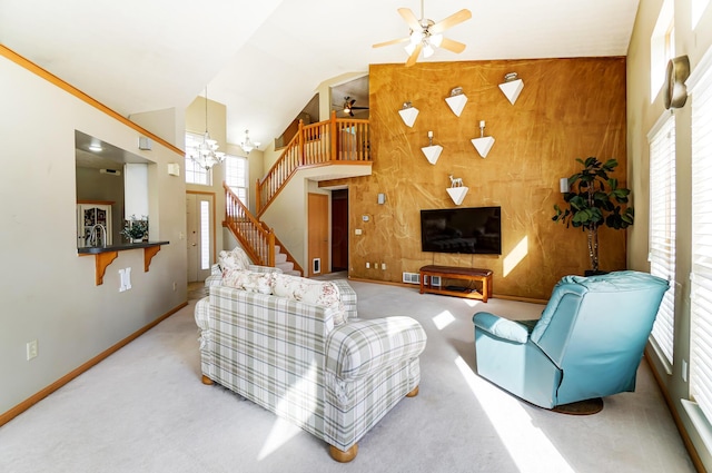 living room featuring ceiling fan with notable chandelier, high vaulted ceiling, and carpet flooring